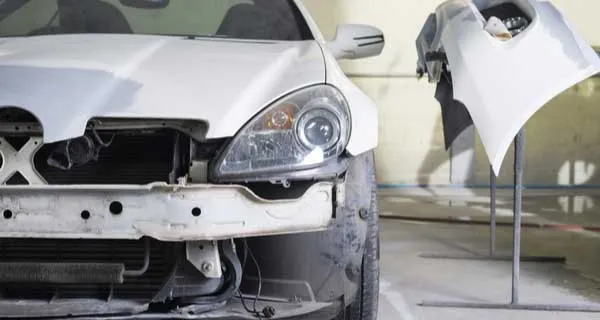 Technician repairing a dented vehicle panel at RX Collision
